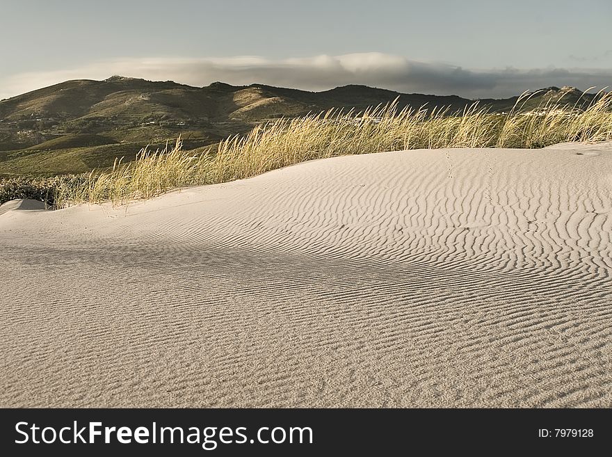 Detail of a sand dune with Sintra mountain at background. Detail of a sand dune with Sintra mountain at background