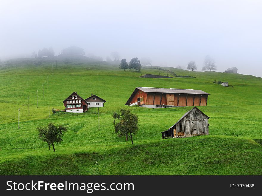 Cloudy time in Swiss alps, miniature chalet on the green mountains slope. Cloudy time in Swiss alps, miniature chalet on the green mountains slope