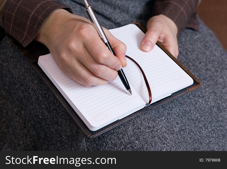 Female hand writes notes in notebook
