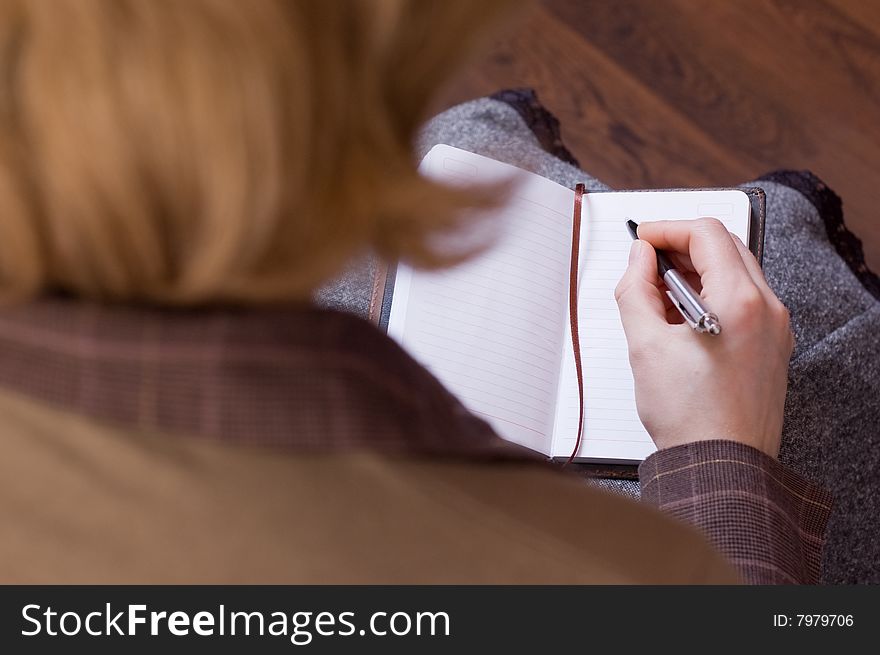 Female writes notes in notebook