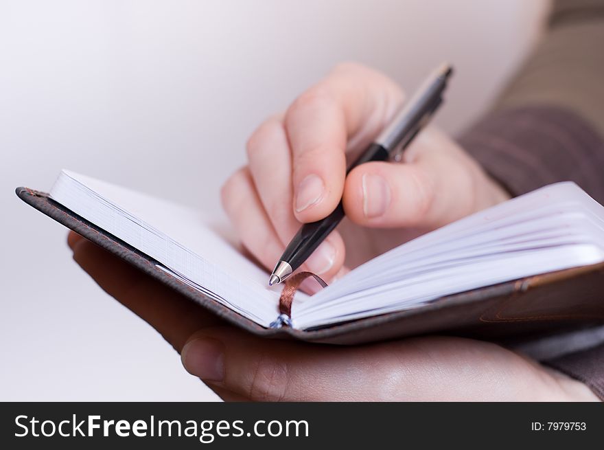 Female writes notes in notebook by pen. Female writes notes in notebook by pen