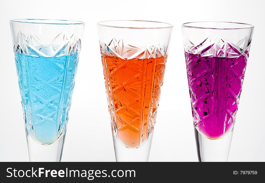 Three wineglass with drink blue, red and magenta colors