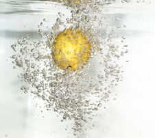 Lemon Is Dropped Into Fresh Water. Royalty Free Stock Photography