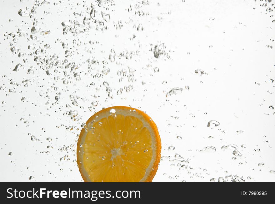 Slice of orange is dropped into fresh water. Slice of orange is dropped into fresh water.
