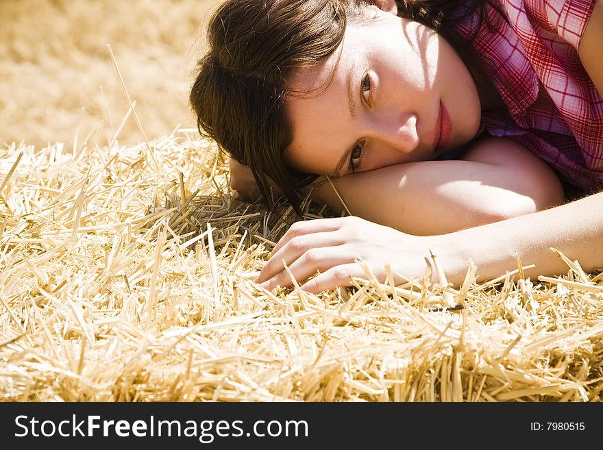 Young farmer laying on haystack under the sun. Young farmer laying on haystack under the sun.