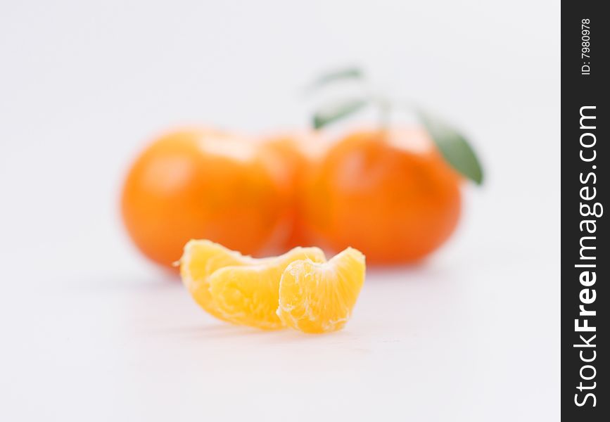 Three clementines with segments on a white background