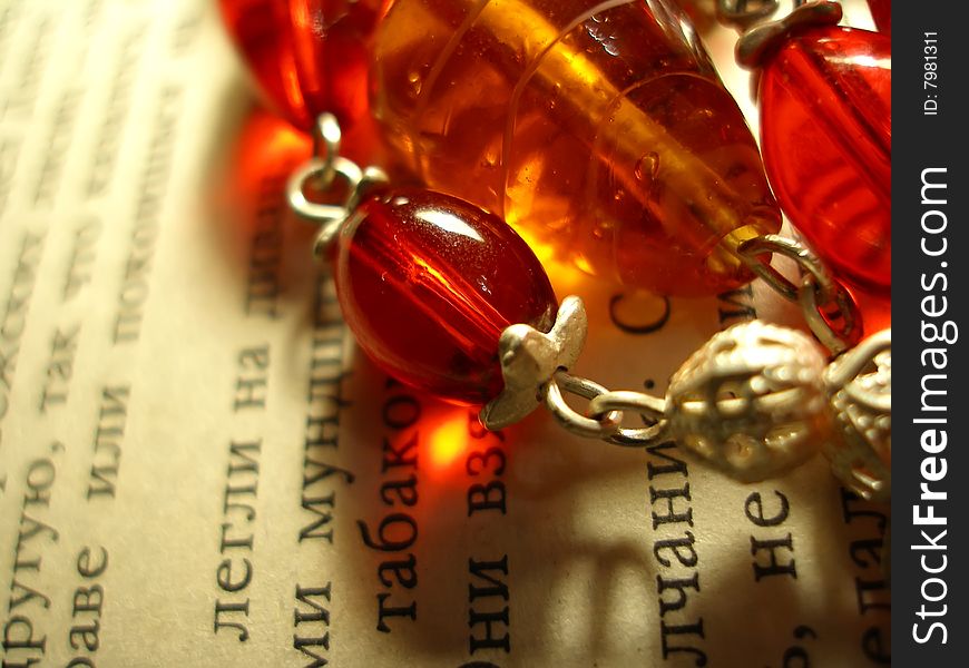 The red & yellow necklace on the book page. The red & yellow necklace on the book page