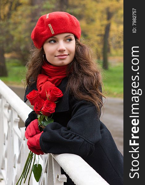 Romantic girl with roses in the autumn park