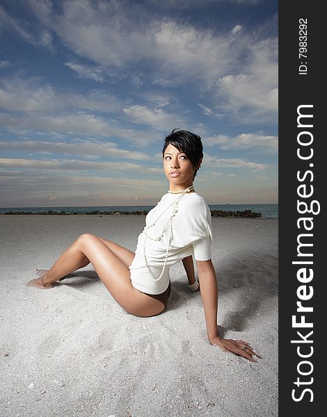 Beautiful young woman sitting on the sand. Beautiful young woman sitting on the sand