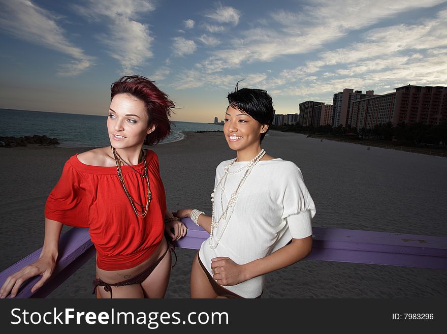 Two beautiful model type women on the beach during dusk