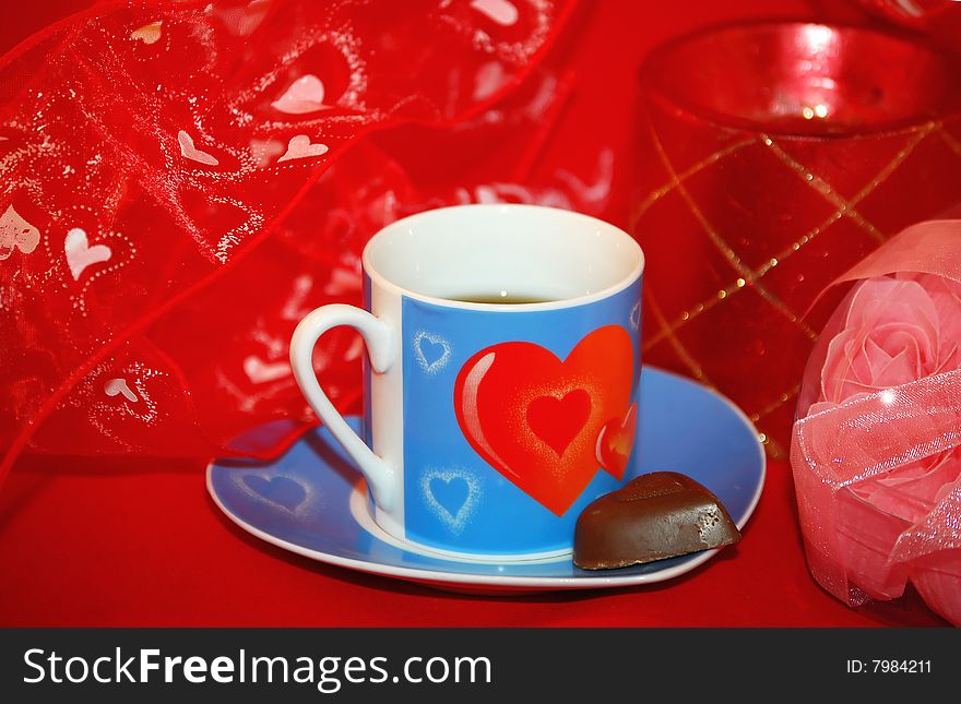 Blue little mug with two red hearts is on the red background. Blue little mug with two red hearts is on the red background.