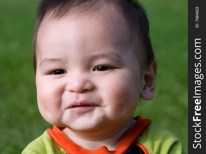 Adorable asian toddler sitting outside laughing. Adorable asian toddler sitting outside laughing