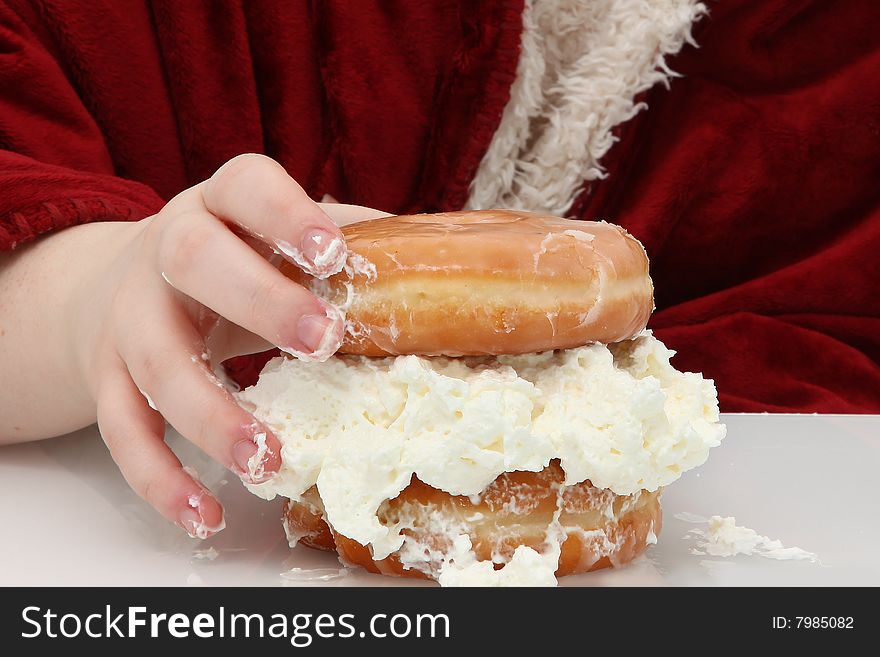 Teen girl hand on glazed donuts with whipped topping in between. Teen girl hand on glazed donuts with whipped topping in between.