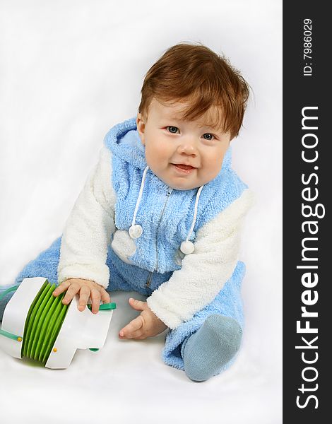 Happy small seven-month baby-boy It holds the toy. Isolated on white. Happy small seven-month baby-boy It holds the toy. Isolated on white