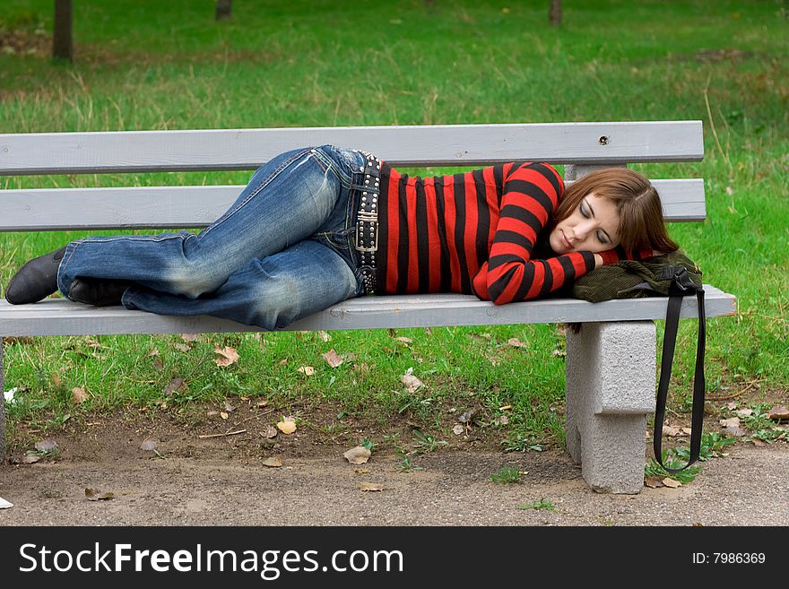 Young girl sleeping on a park bench