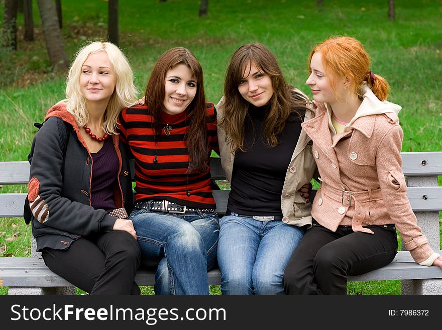 Four Girls Sitting On A Park Bench