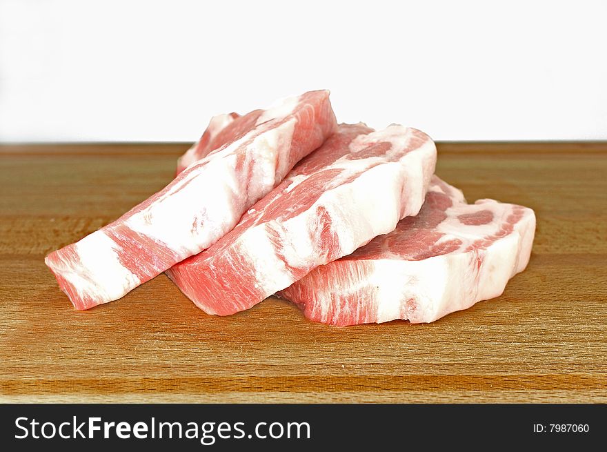 Three slices of pork chops on a wooden cutting board. Three slices of pork chops on a wooden cutting board.