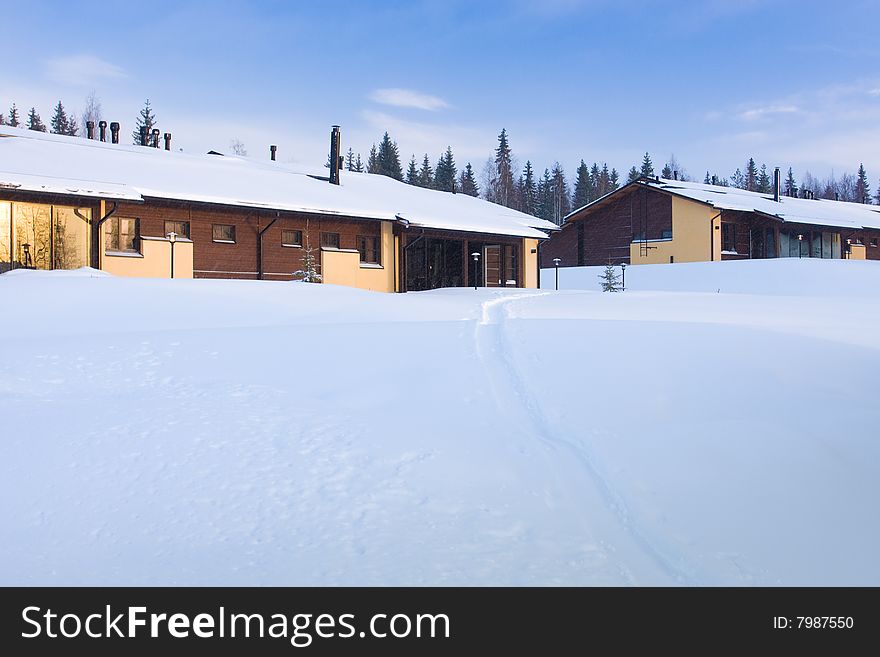 Cottages covered by snow and a trail. Cottages covered by snow and a trail