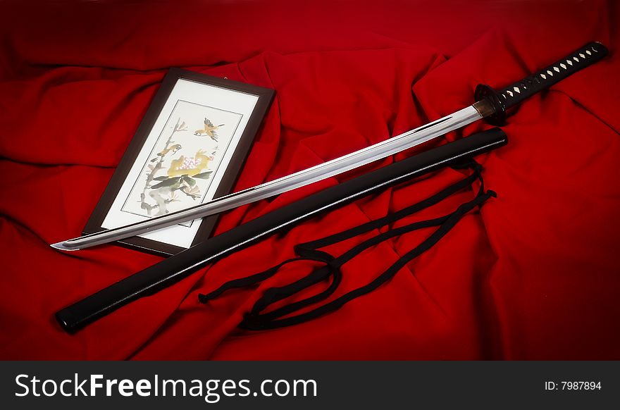 Real Japanese sword and picture on a red fabric