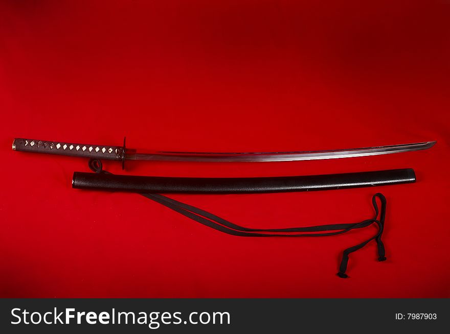 Real Japanese sword and picture on a red fabric. Real Japanese sword and picture on a red fabric