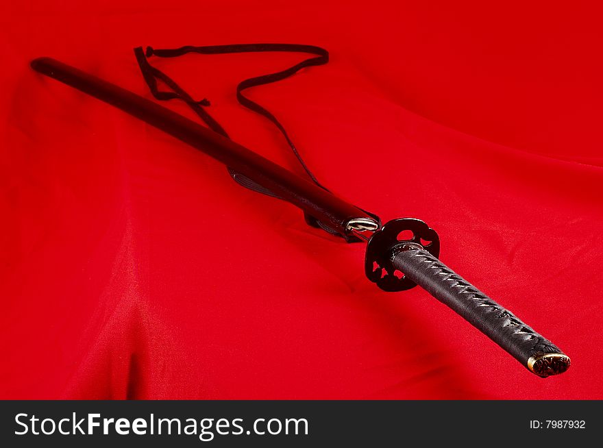 Real Japanese sword and picture on a red fabric. Real Japanese sword and picture on a red fabric