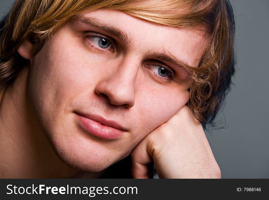 Young man with a serious look over grey background. Young man with a serious look over grey background