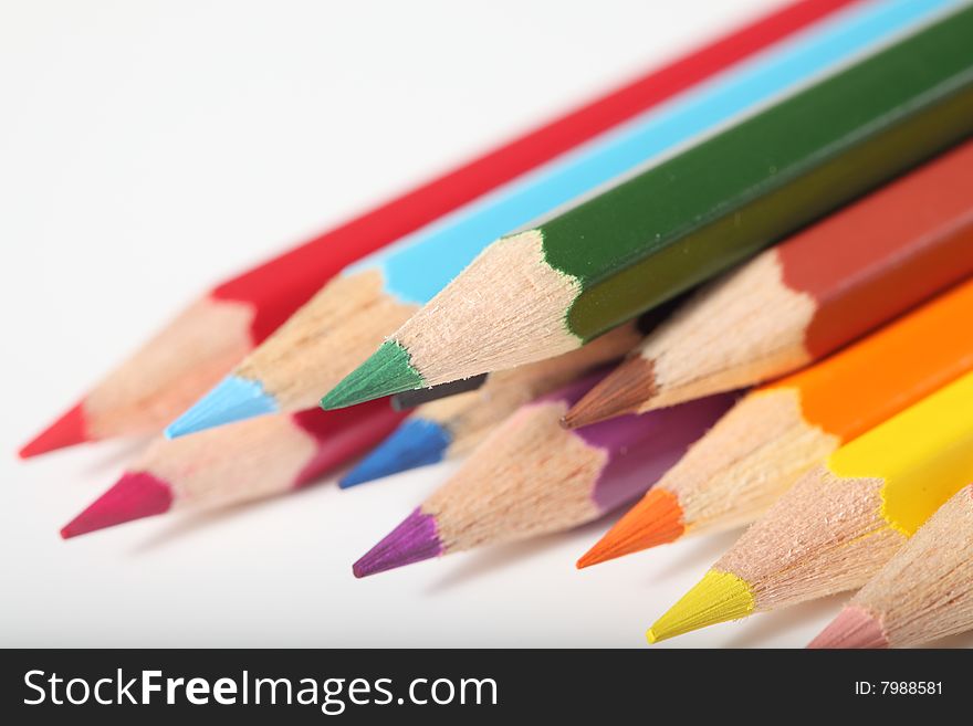 Macro pencil cluster points down left green focus on white background