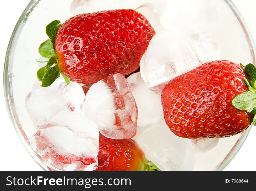 Strawberries with ice in bowl on white ground