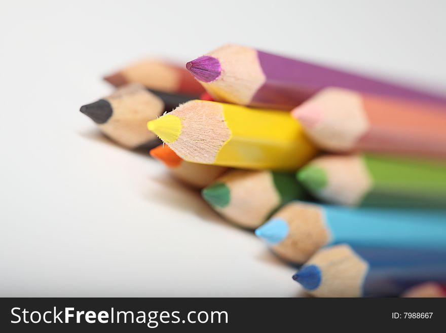 Macro pencil cluster points out yellow focus on white background