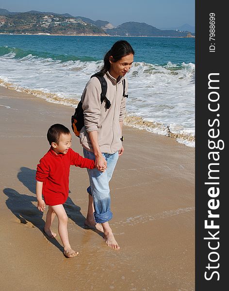 Father and Son Walking in the surfy beach