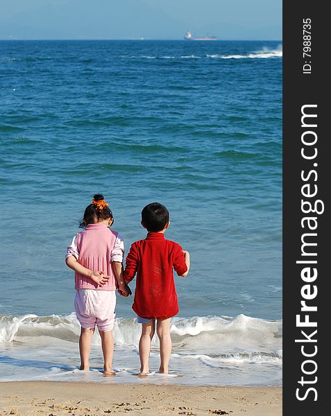 Young Kids Playing in the surfy beach. Young Kids Playing in the surfy beach