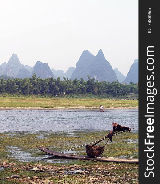 Guilin to Yangshuo cruise. fisherman's boat in the front, with lake and mountains in the background. Guilin to Yangshuo cruise. fisherman's boat in the front, with lake and mountains in the background.