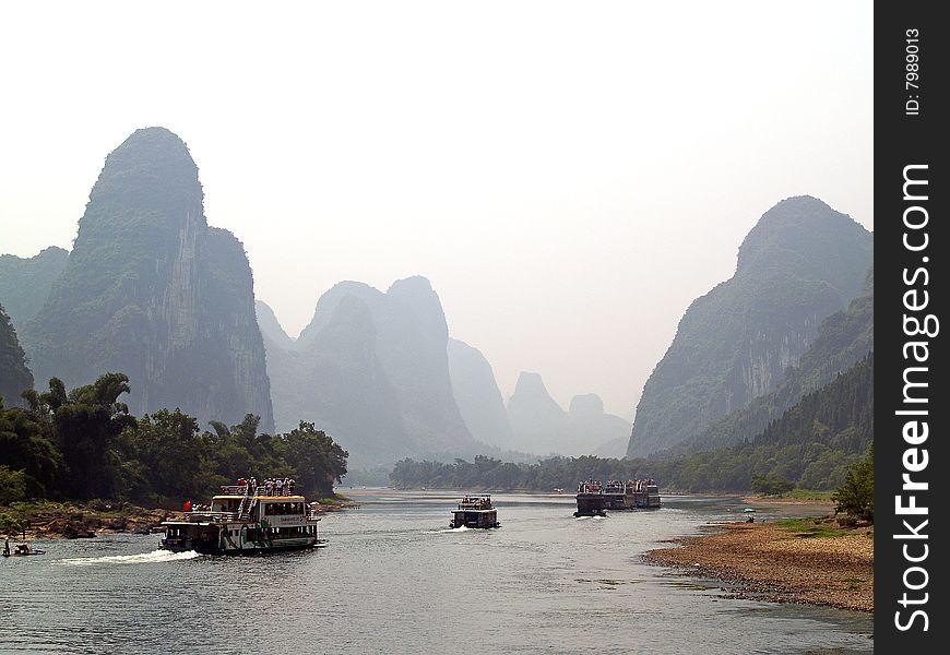 Guilin to Yangshuo cruise. convoy of tourist boats going down the river. Guilin to Yangshuo cruise. convoy of tourist boats going down the river.