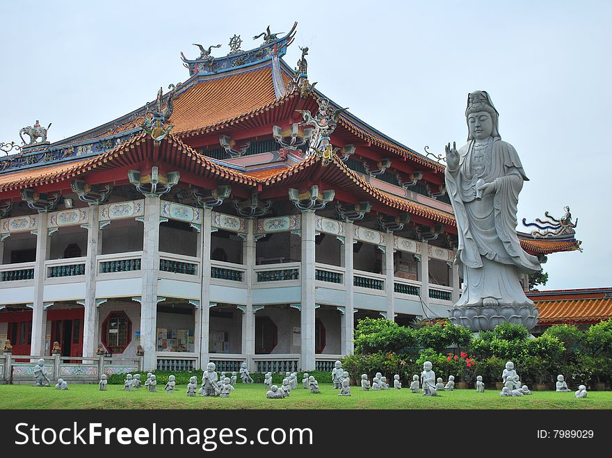 Buddha statue with other smaller statues near a golden stupa. Buddha statue with other smaller statues near a golden stupa