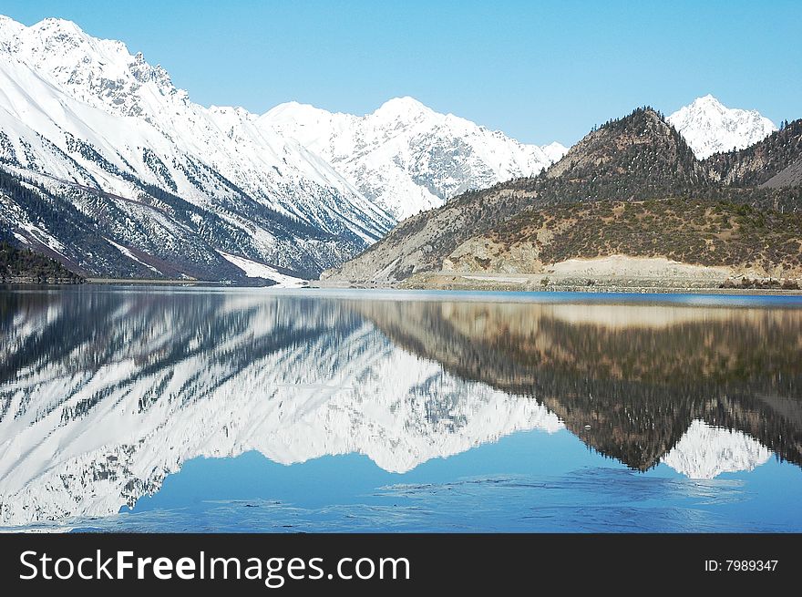 Snow Mountains and their mirror in the lake,Tibet,in a Spring morning. Snow Mountains and their mirror in the lake,Tibet,in a Spring morning