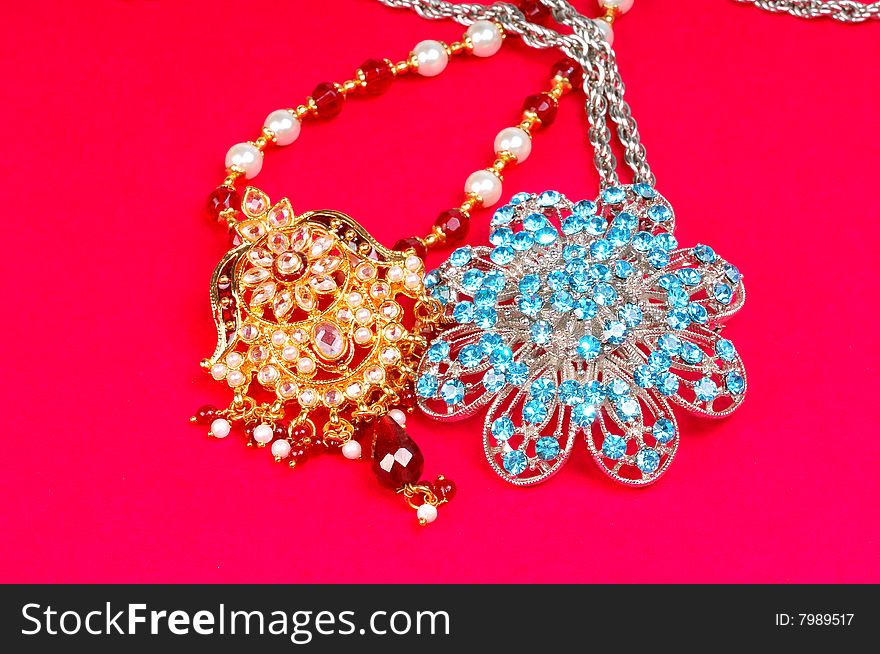 Gold and diamond pendants isolated on colored background.