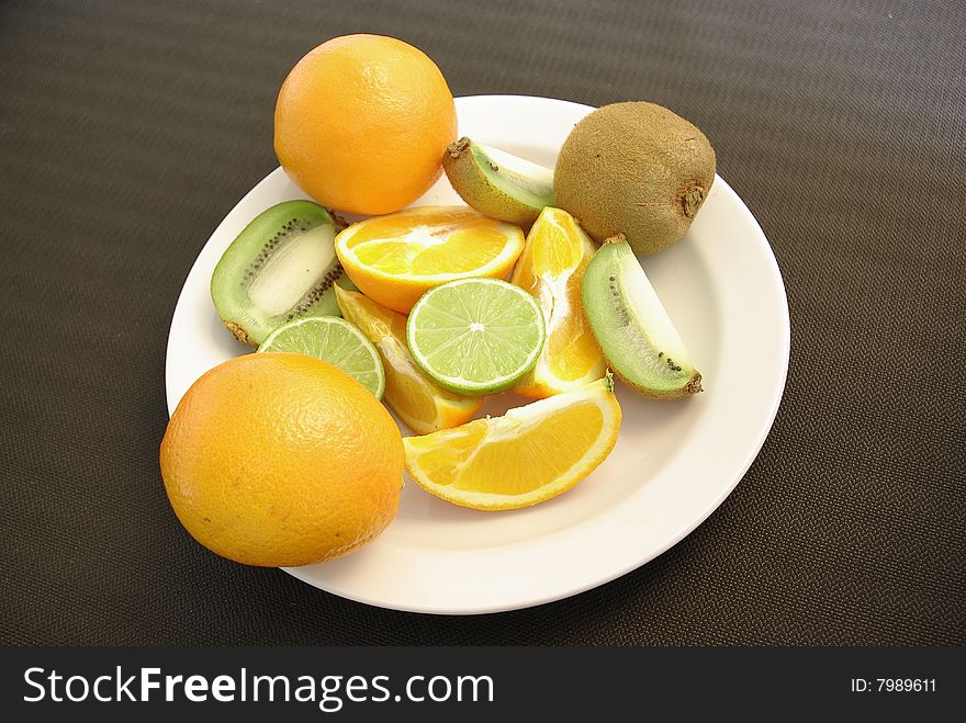 Fruit, citrus and kiwi on white plate