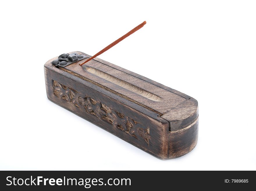 A small wooden box and an incense stick on a white background. A small wooden box and an incense stick on a white background.