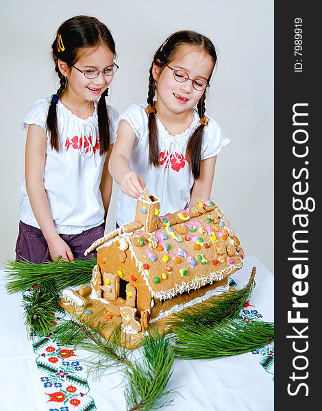 Twins decorating a gingerbread house