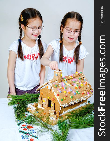 Twins decorating a gingerbread house