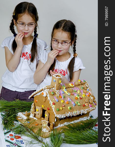 Twins decorating a gingerbread house