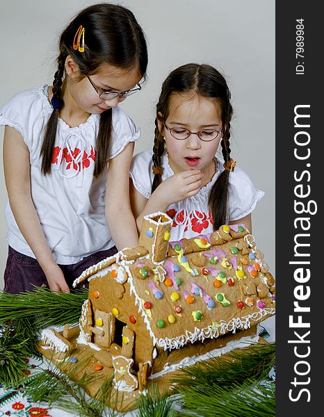 Twins decorating a gingerbread house