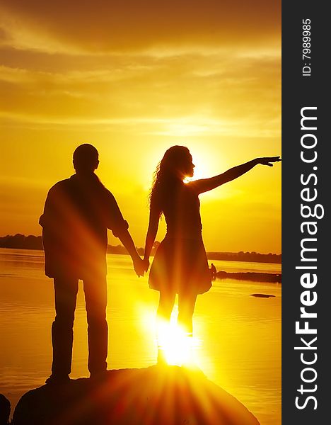 Silhouette the man and woman on a background sunset. Silhouette the man and woman on a background sunset
