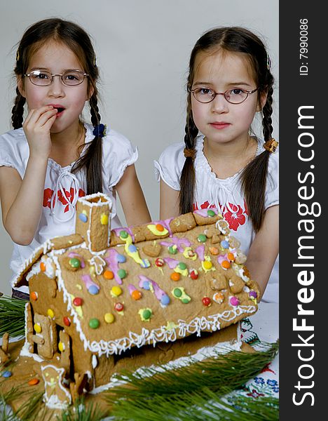 Twins decorating a gingerbread house