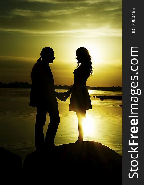 Silhouette the man and woman worth on a background sunset