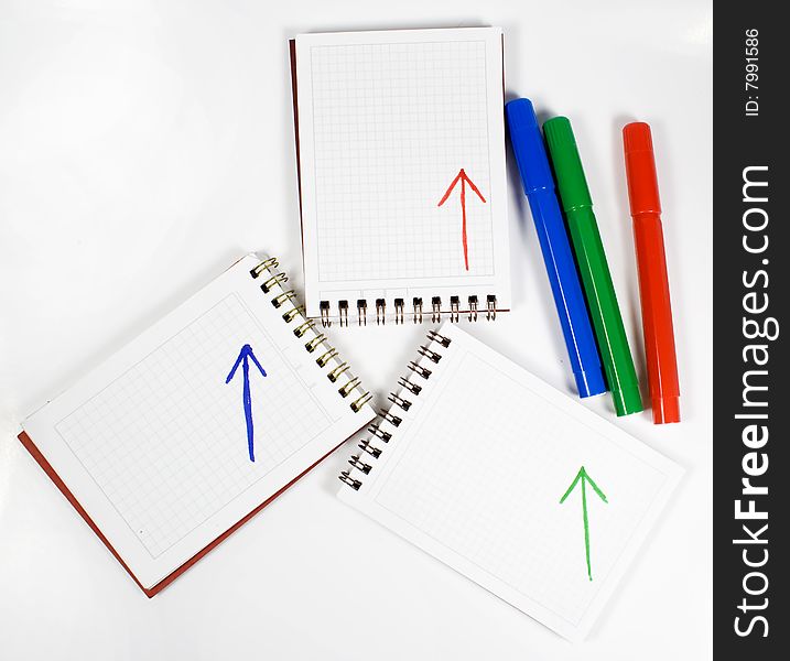 Three open notebooks with arrows and colors felt-tip pens. Three open notebooks with arrows and colors felt-tip pens
