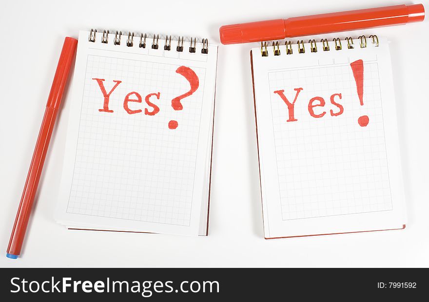 Two open notebook with inscription and red felt-tip pens