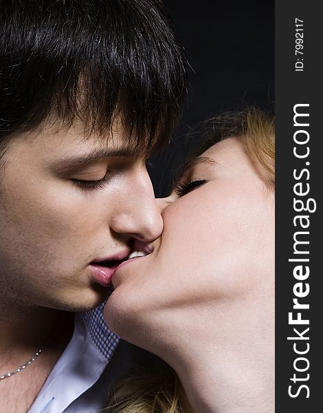 Kissing couple isolated over black background