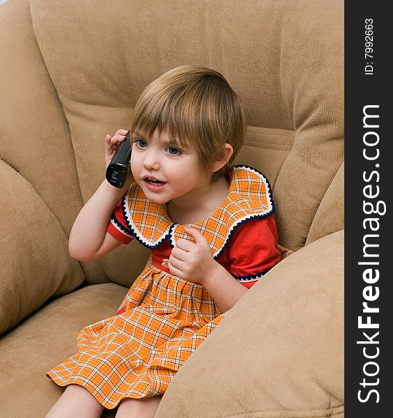 The little girl speaks by phone. The little girl speaks by phone