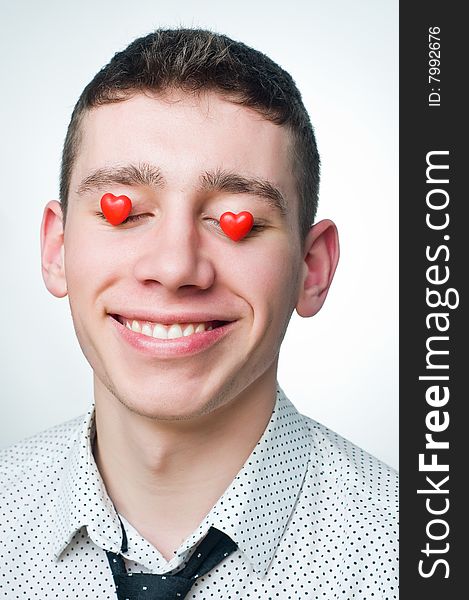 Portrait of a smiling man with heart-shaped candies over his eyes